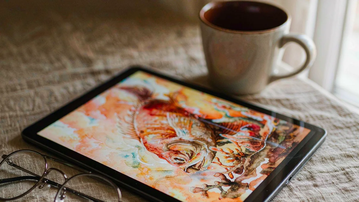 A tablet on a linen surface showing a blurred digital illustration