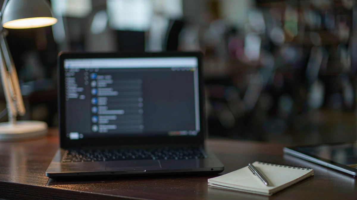 An open laptop displaying a blurred account settings screen on a dark desk